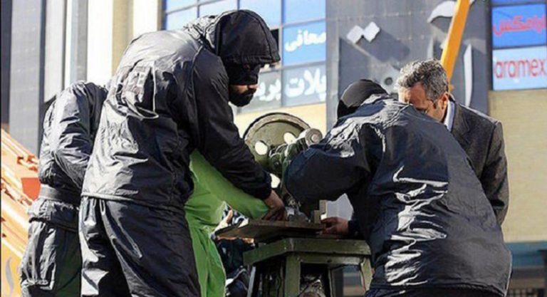 Iranian regime henchmen, amputating a prisoner's hand based on their medieval rules
