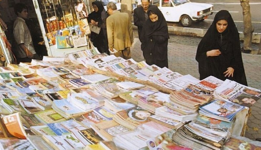 Bystanders in an Iranian street read headlines from state-run newspapers,