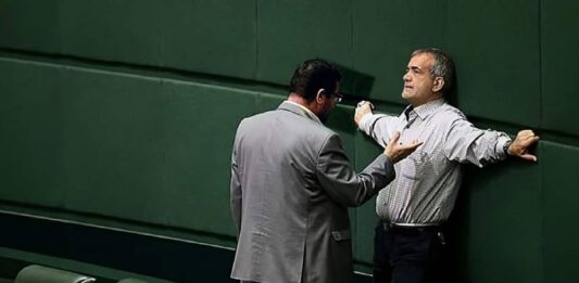 The Iranian regime's president Masoud Pezeshkian appears exhausted, leaning against a wall during a tense parliamentary session in Tehran, July 2024