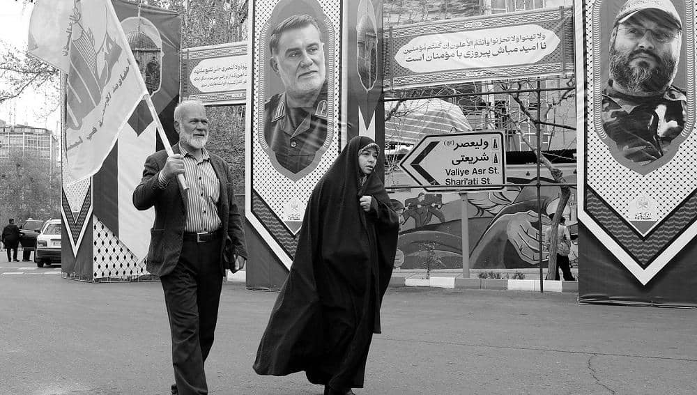 A couple carrying a Hezbollah flag during the Quds Day march in Iran — March 28, 2025