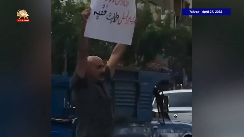 Tehran – April 27, 2025- Former political prisoner Hamid Haj Jafar Kashani holds a placard calling for regime change