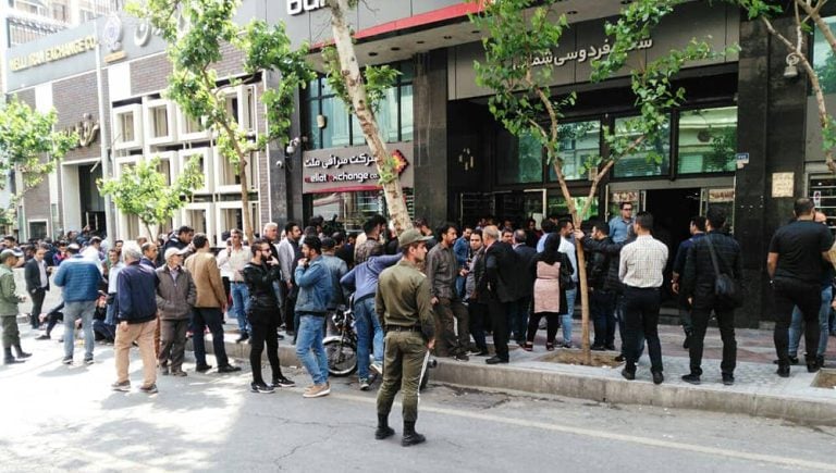 Citizens gather anxiously outside a currency exchange office in Tehran