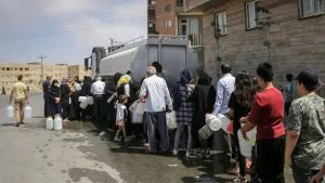 Iranian residents queue for water from a tanker amid worsening shortages and infrastructure failure