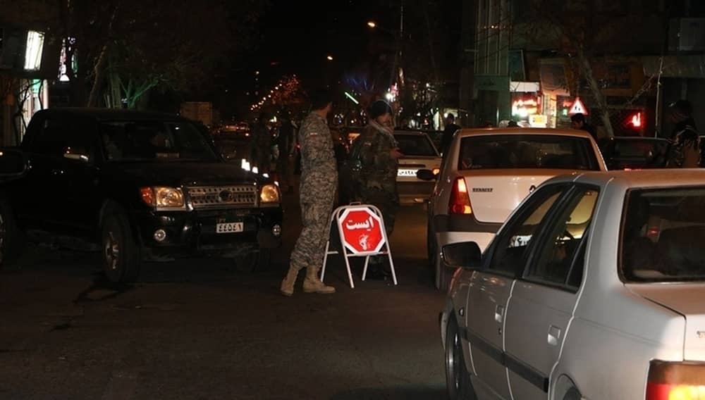 Tehran, Iran — Security forces set up a nighttime checkpoint, stopping cars for inspection.