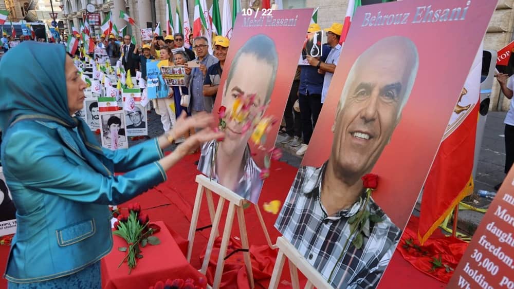 At a memorial rally in Rome on July 30, 2025, Maryam Rajavi lays flowers before portraits of Mehdi Hassani and Behrouz Ehsani