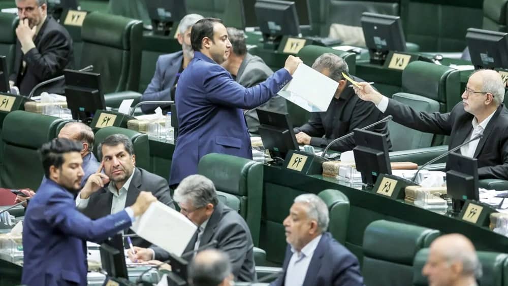 Iranian regime MPs cast their votes during a parliamentary session