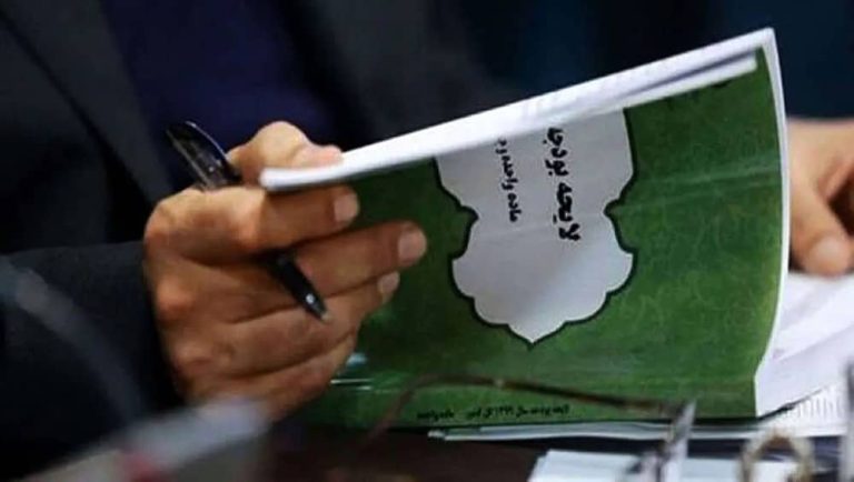 An Iranian official reviews the national budget document