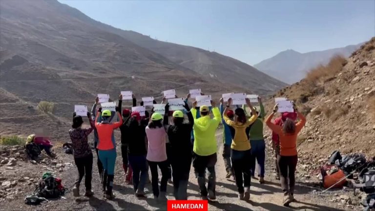 Members of Resistance Units in Hamedan, north-central Iran, display signs bearing Maryam Rajavi's slogan, "We can and we must," while hiking in the mountains near the city