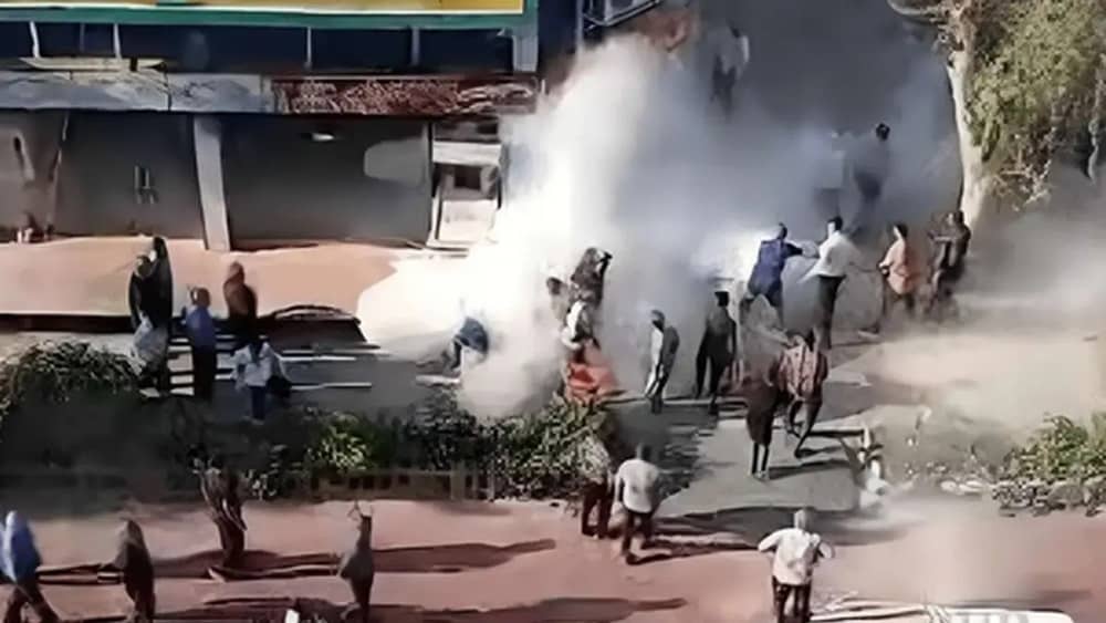 People rush to extinguish flames after Ahmad Baledi set himself on fire outside his family’s demolished food stand in Ahvaz