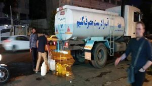 Tehran — Residents collect water from a tanker amid ongoing shortages. The tanker reads, “Let’s use water properly”