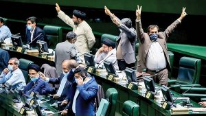 ChatGPT said: Lawmakers gesture and shout across the chamber during a contentious Majles session in Tehran