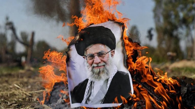 A portrait of the Iranian regime’s Supreme Leader burns amid open flames