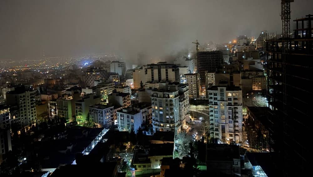 Smoke rises over Tehran’s skyline at night in March 2026