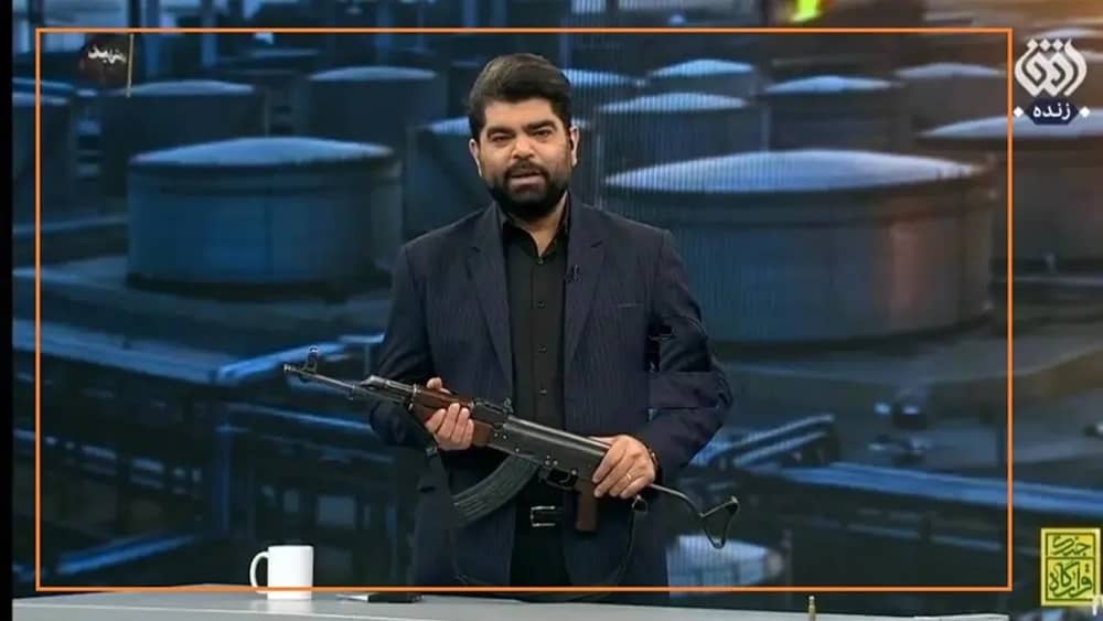 Iranian state TV presenter posing with a Kalashnikov on live air— May 2026