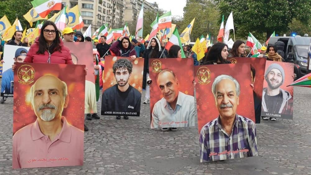 Supporters of the NCRI hold large portraits of executed political prisoners and dissidents during a demonstration, honoring those who lost their lives to state repression— May 2026
