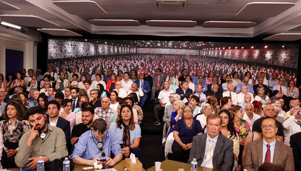 Participants in Paris, joined by residents of Ashraf 3 via video link, listen to international dignitaries at the the Free Iran 2026 World Summit on June 21, 2026