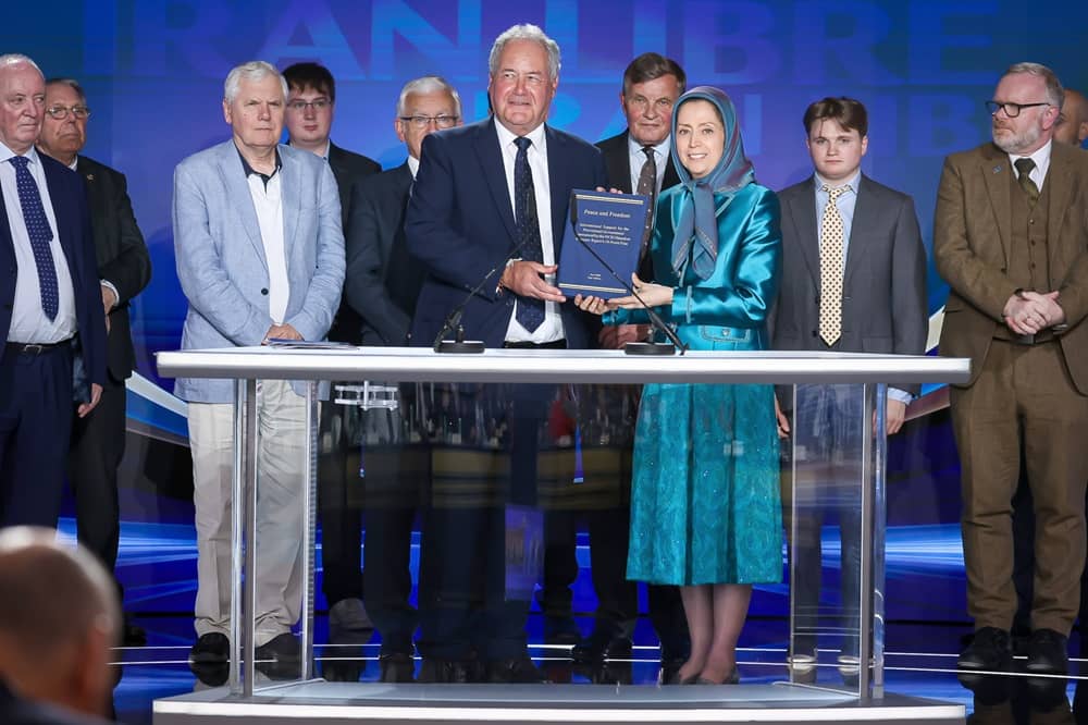 UK MP Bob Blackman, leading the British delegation, presents a book bearing more than 3,000 signatures supporting the NCRI's Provisional Government in 2026 to Mrs. Maryam Rajavi, June 21, 2026