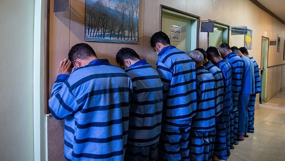 An official handout photo distributed by the Iranian regime's judiciary media, staging a line of detainees facing a wall—a visual tactic routinely deployed by state security apparatuses to project total authority