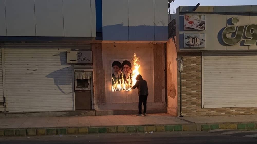 Grok AI enhanced image based on real footage shows a Resistance Units member lit a regime billboard during a nighttime operation in the southeastern city of Zahedan