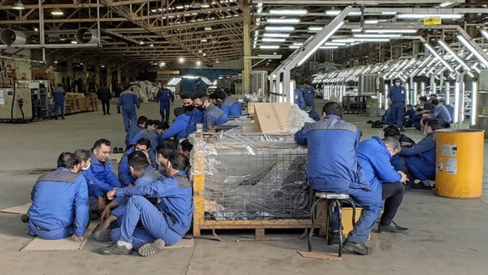 Factory workers idle amid production halt caused by power outages, underscoring the growing strain of energy shortages on Iran’s industrial workforce and employment