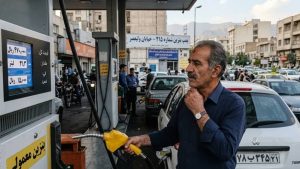 An Iranian citizen looks on with evident concern while refueling his vehicle at a gas station on Valiasr Street in Tehran