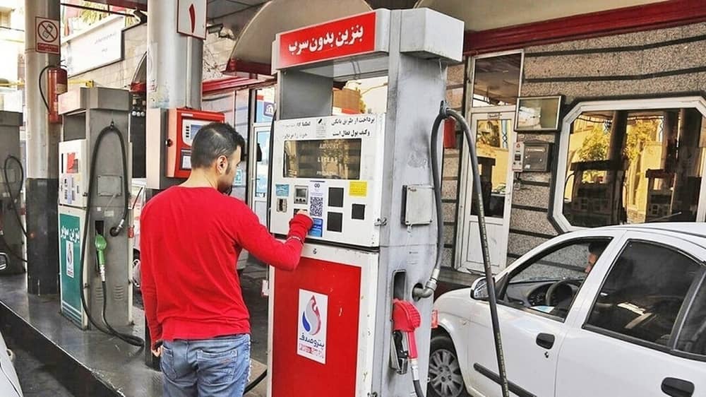 A motorist operates a fuel pump at a gas station in Iran