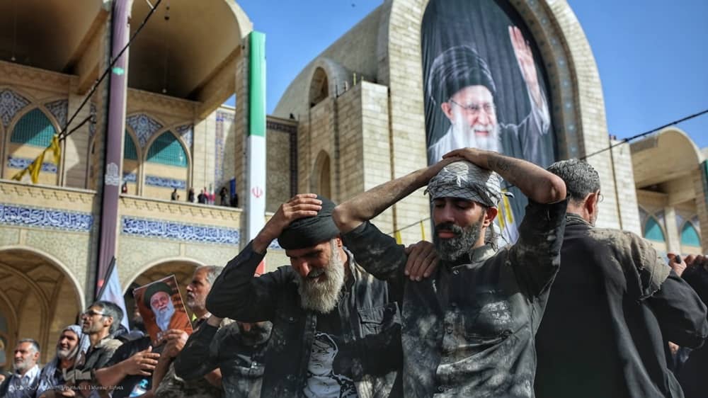 Dusty “Basij” extras clutch their heads and stare skyward—not in grief or prayer, but for the camera