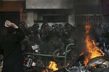 An Iranian protester throws a stone at riot police as protesters set their motorbikes on fire during fierce clashes in central Tehran December 27, 2009 An Iranian protester throws a stone at riot police as protesters set their motorbikes on fire during fierce clashes in central Tehran December 27, 2009