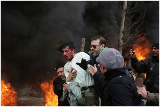 an Iranian police officer, center with white shirt, is protected and is taken away by people after being beaten by protestors during anti-government protest at the Enqelab (Revolution) St. in Tehran, Iran an Iranian police officer, center with white shirt, is protected and is taken away by people after being beaten by protestors during anti-government protest at the Enqelab (Revolution) St. in Tehran, Iran