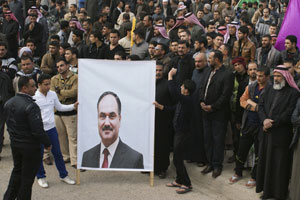 Iraqi protesters holding a portrait of Dr. Al-Issawi