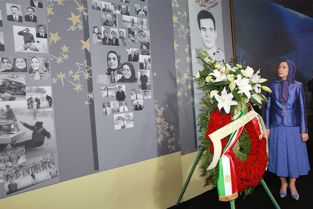 maryam-rajavi-1-1024 Iranian opposition leader Maryam Rajavi stands next to a memorial for 120,000 ‘martyrs of freedom in Iran’ during grand gathering in Parc des Expositions exhibition center on June 13, 2015 in Villepinte