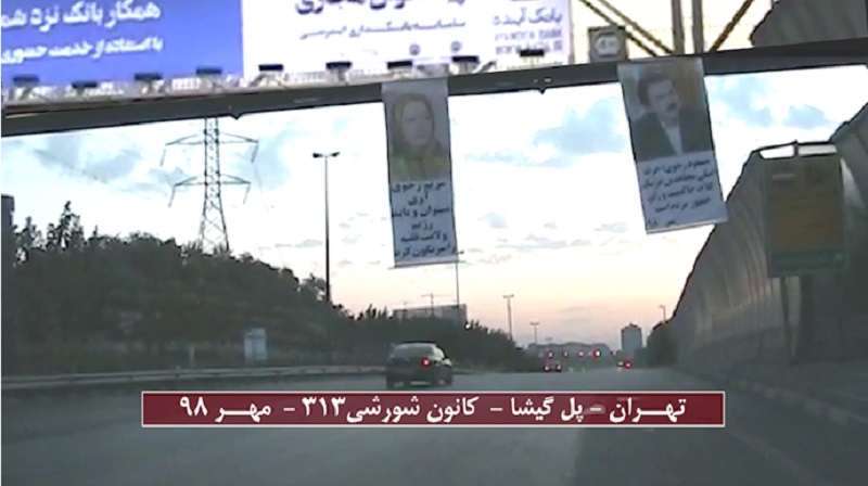Massoud_Rajavi_Maryam_Rajavi_banner_in_Tehran_Iran_2019 Banners of the Iranian opposition leaders (Massoud Rajavi and Maryam Rajavi) hung from a pass-over in one of Tehran's main motorways